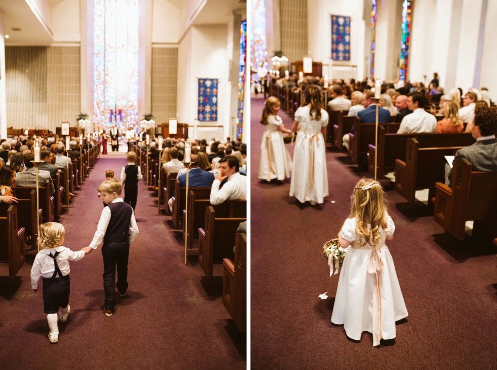 ring bearers and flower girl walking down aisle during church wedding ceremony
