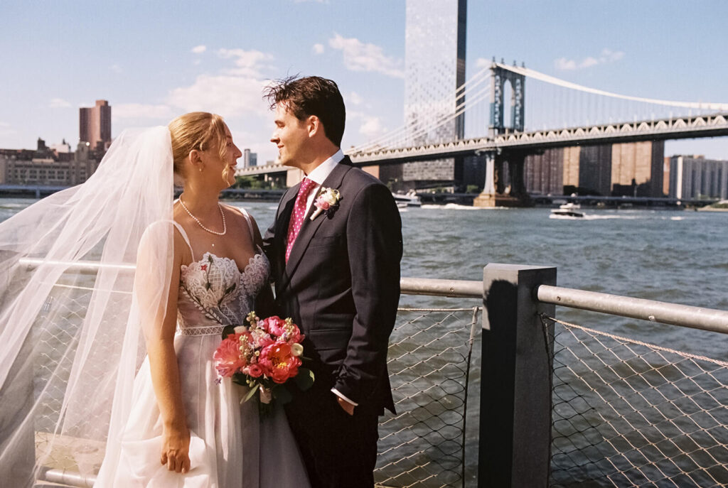 Bride and groom portraits along a  the waterfront in Brooklyn Bridge Park. Photo by OkCrowe Photography. 