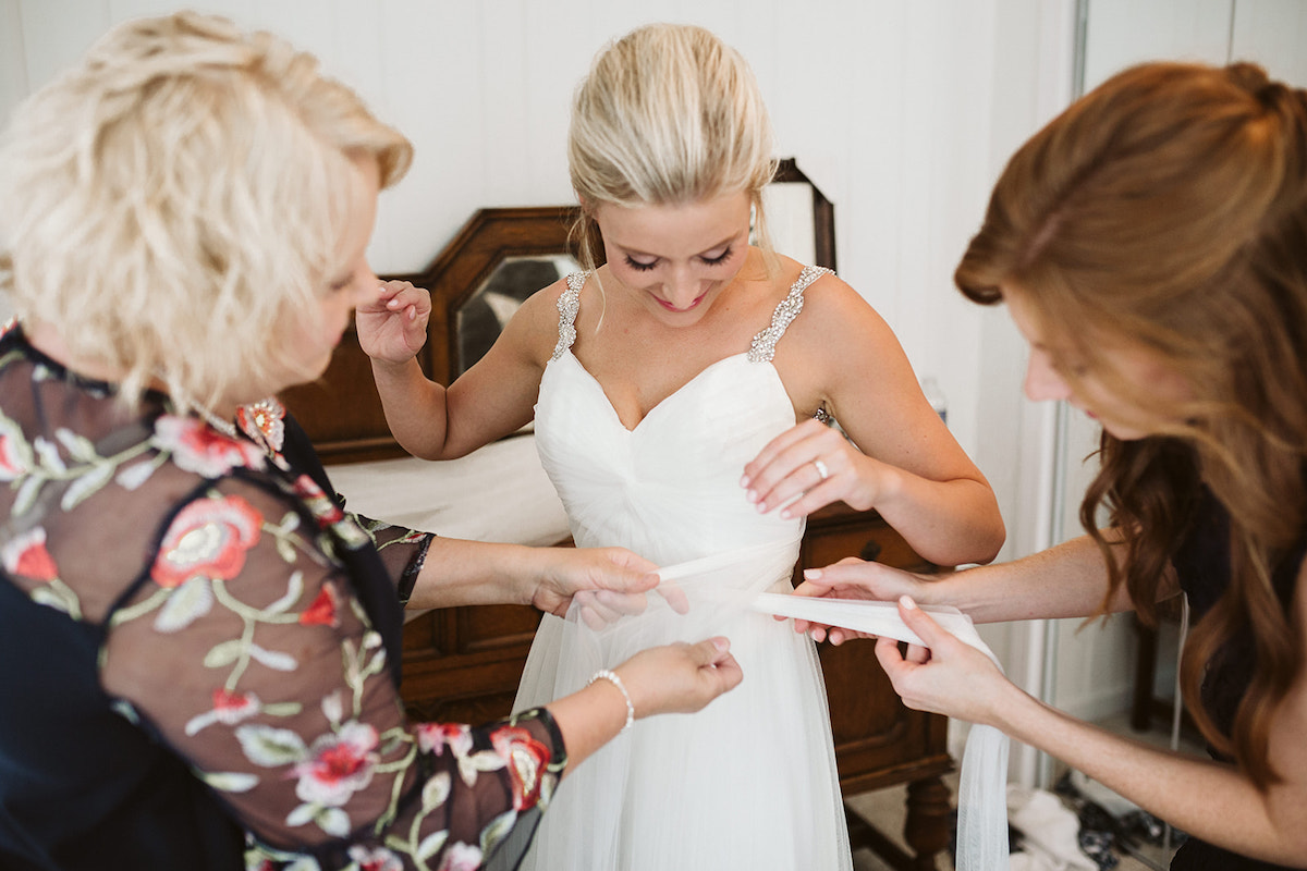 Friends tie waist ribbon bride's wedding dress