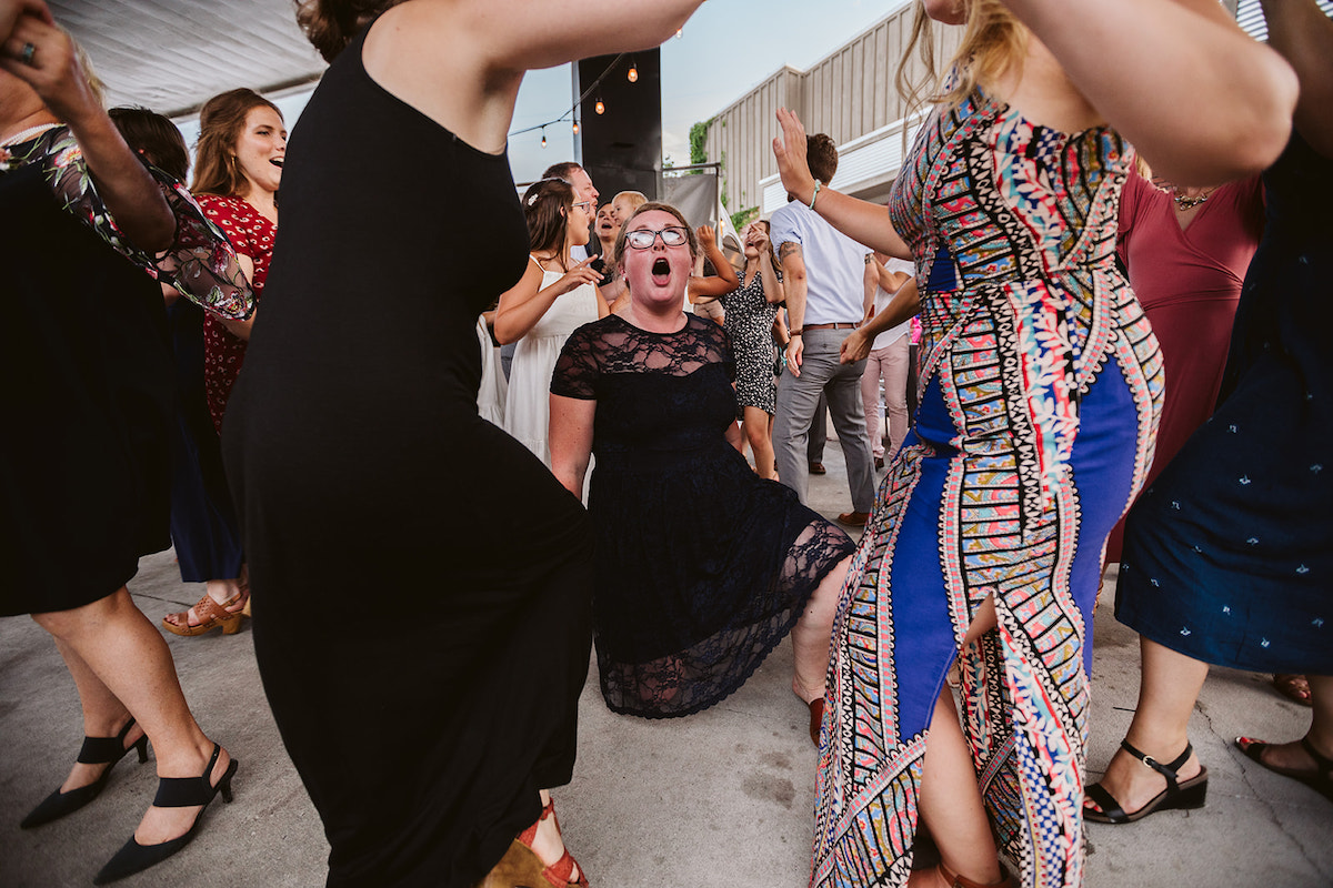 Women dance together, one woman kneels and sings