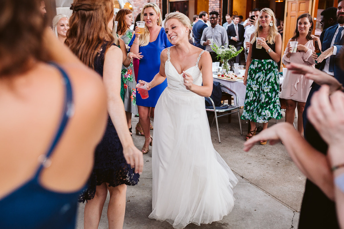 Bride dances with friends as others watch