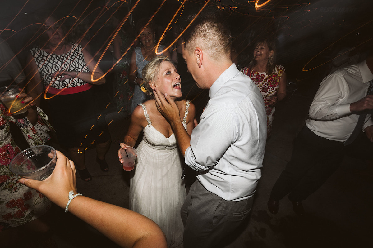 Bride and groom dance and sing to each other, his hand caresses her cheek