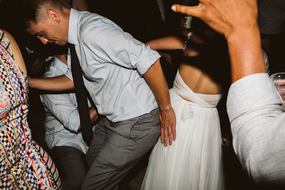 Bride and groom dance with party-goers at their reception