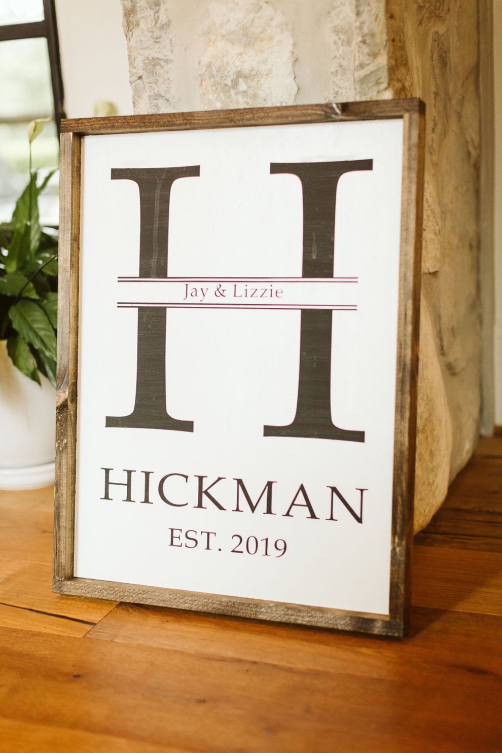 custom wedding day sign with large H and couple's last name printed above "est. 2019"