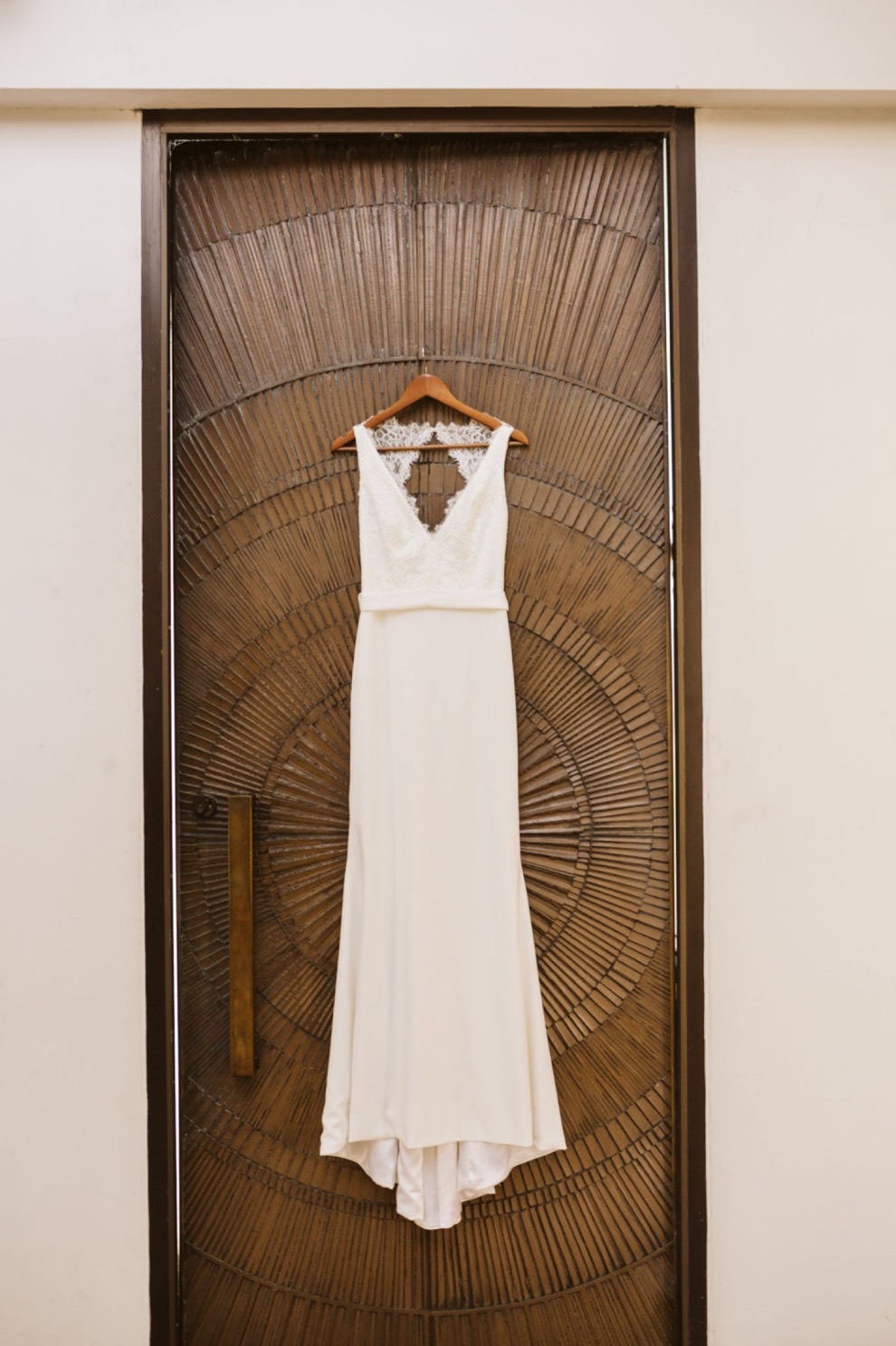 BHLDN bridal dress hanging on wooden door