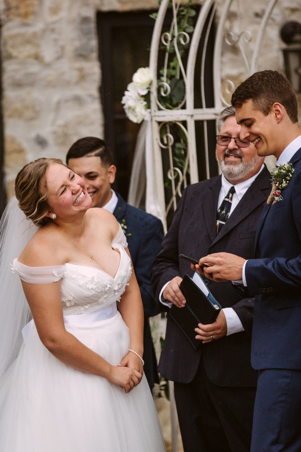 bride and groom laughing with each other during wedding ceremony