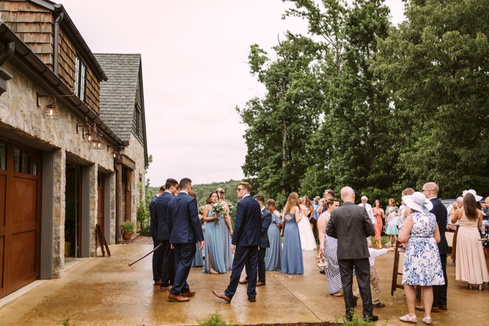 guests mingling on a driveway near a stone house after Georgia backyard wedding ceremony