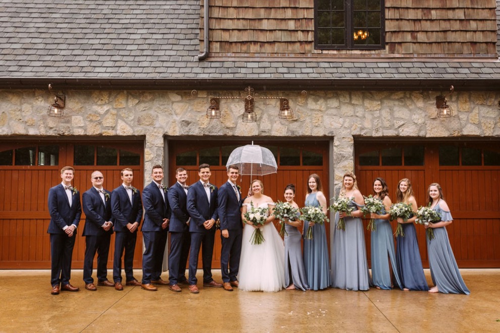 bridal party posing for photos in front of wooden garage doors