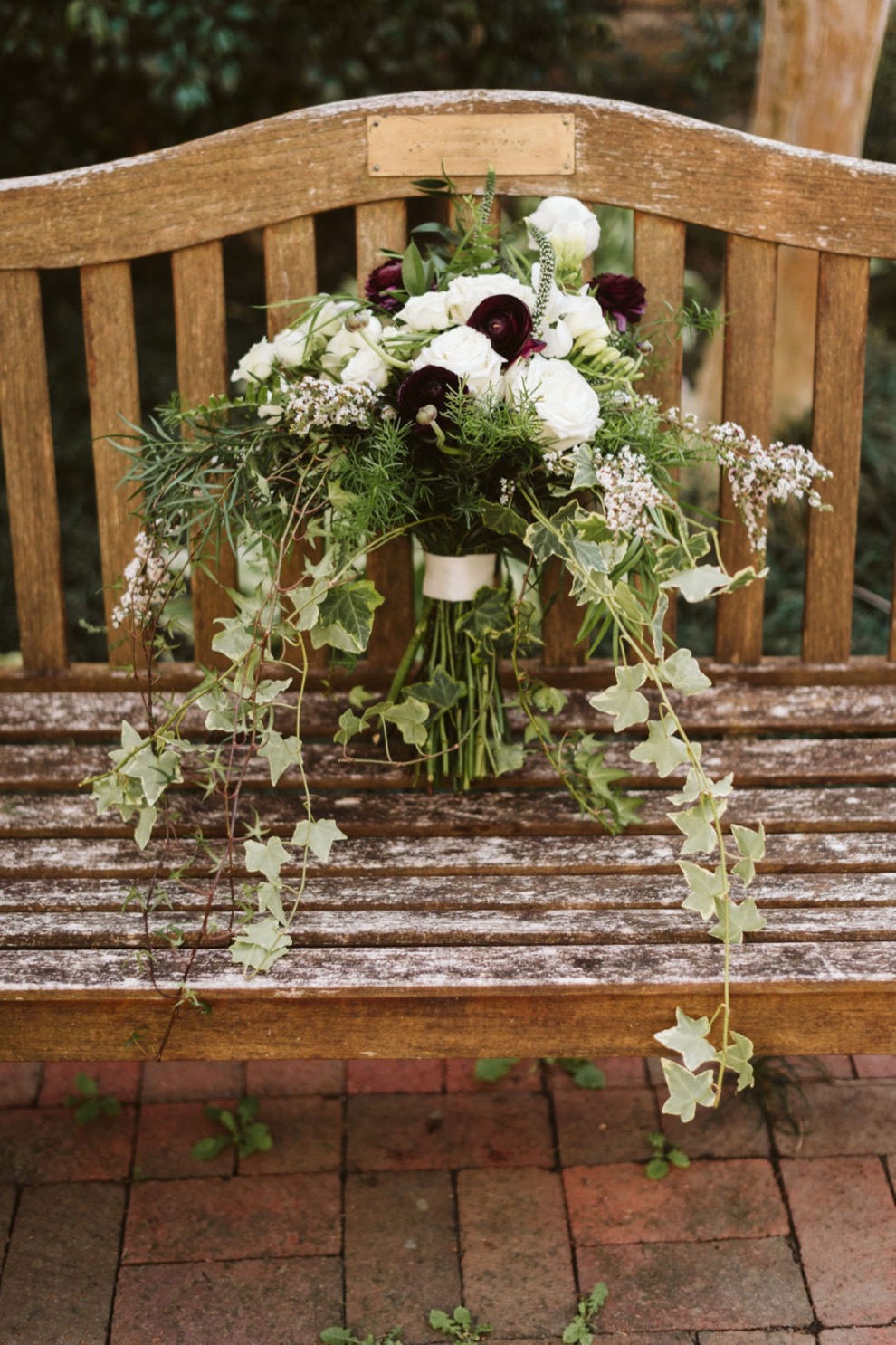 wedding day bouquet resting on wooden bench