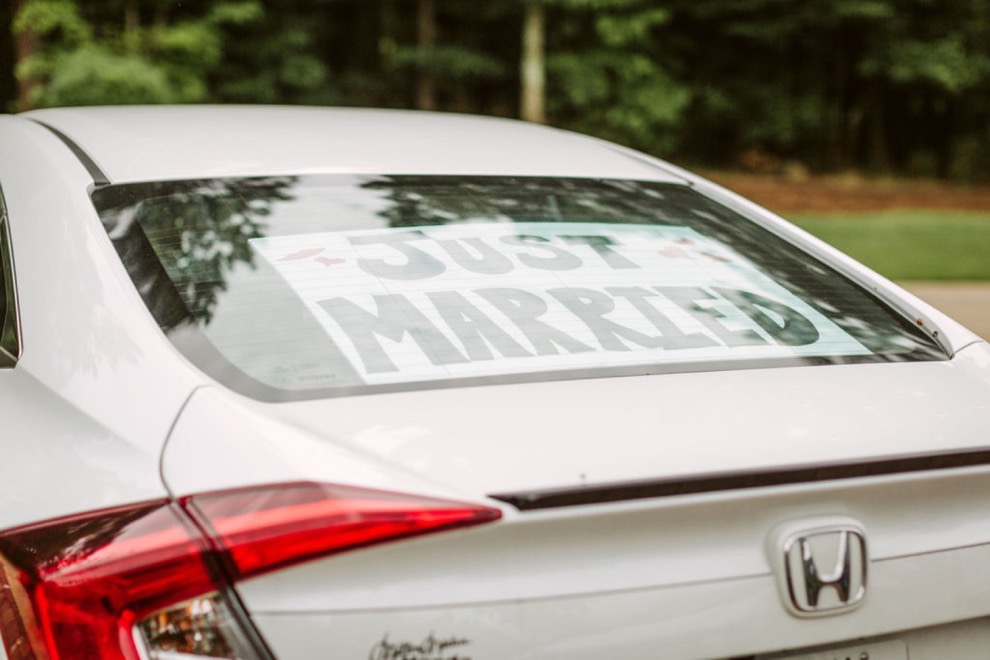 just married sign in rear window of white Honda