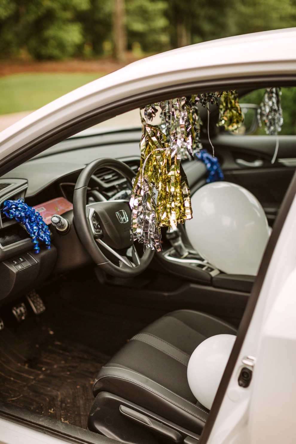 wedding day getaway car decorated with balloons and ribbon