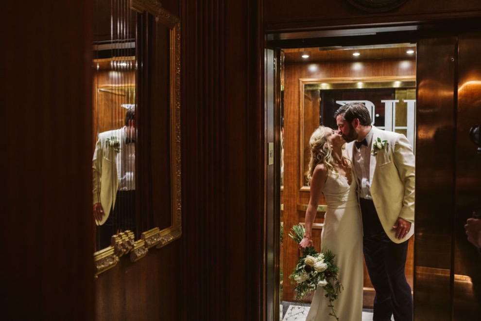 bride and groom kissing in vintage wooden elevator