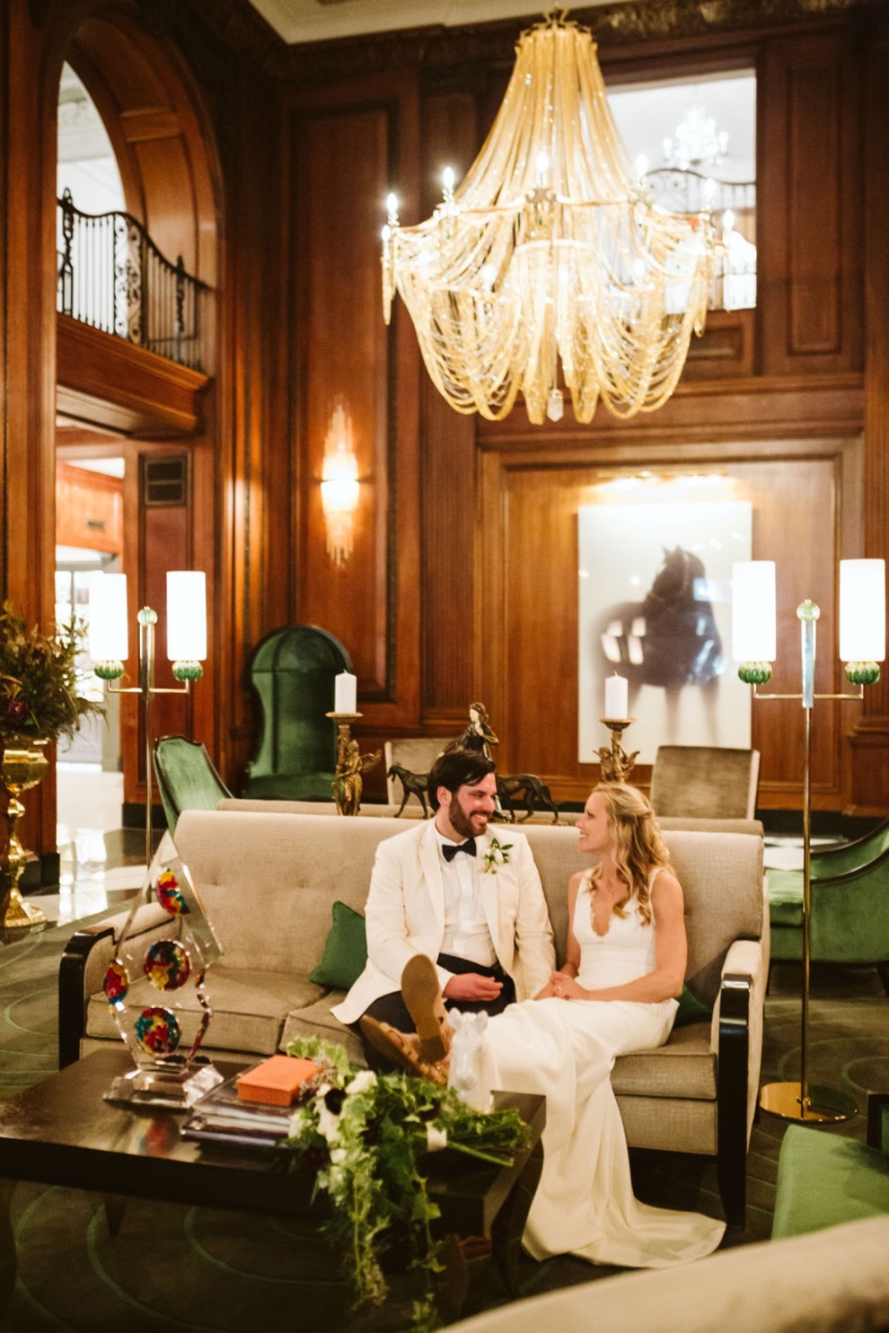 bride and groom sitting on couch in vintage hotel lounge