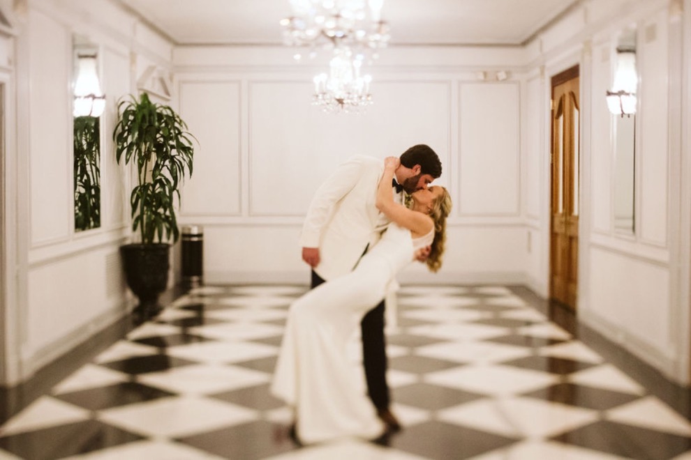 bride and groom kissing in elegant hotel lounge