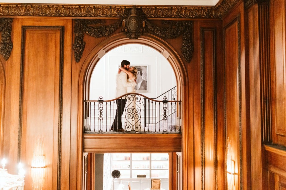 bride and groom kissing in elegant hotel hallway