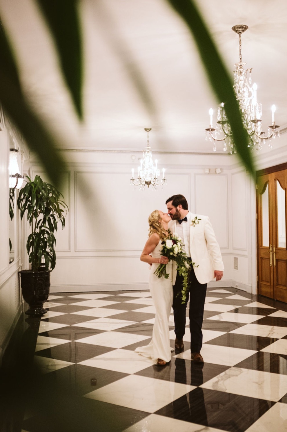 Bride and groom walking arm in arm down elegant hotel hallway
