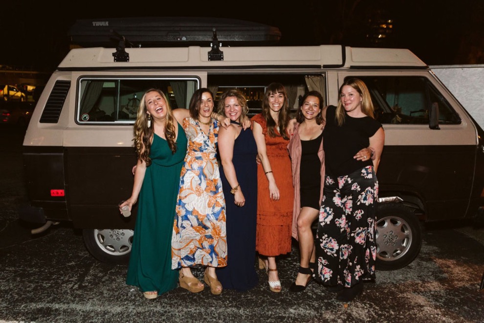 wedding guests posing beside vintage VW van