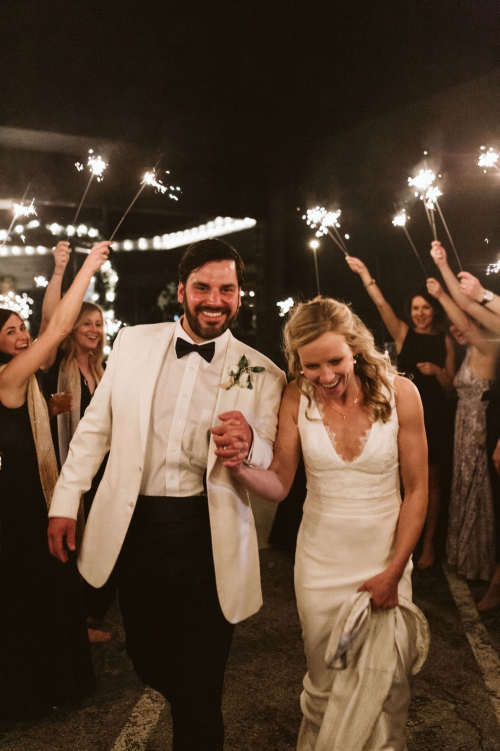 bride and groom walking through line of guests holding sparklers