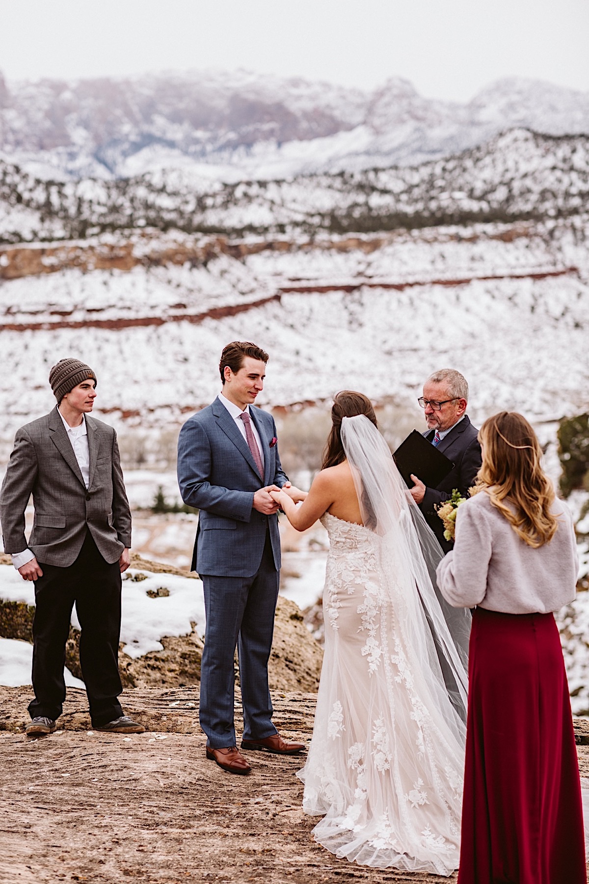 Bride and groom hold hands and exchange vows on a cliffside in Zion