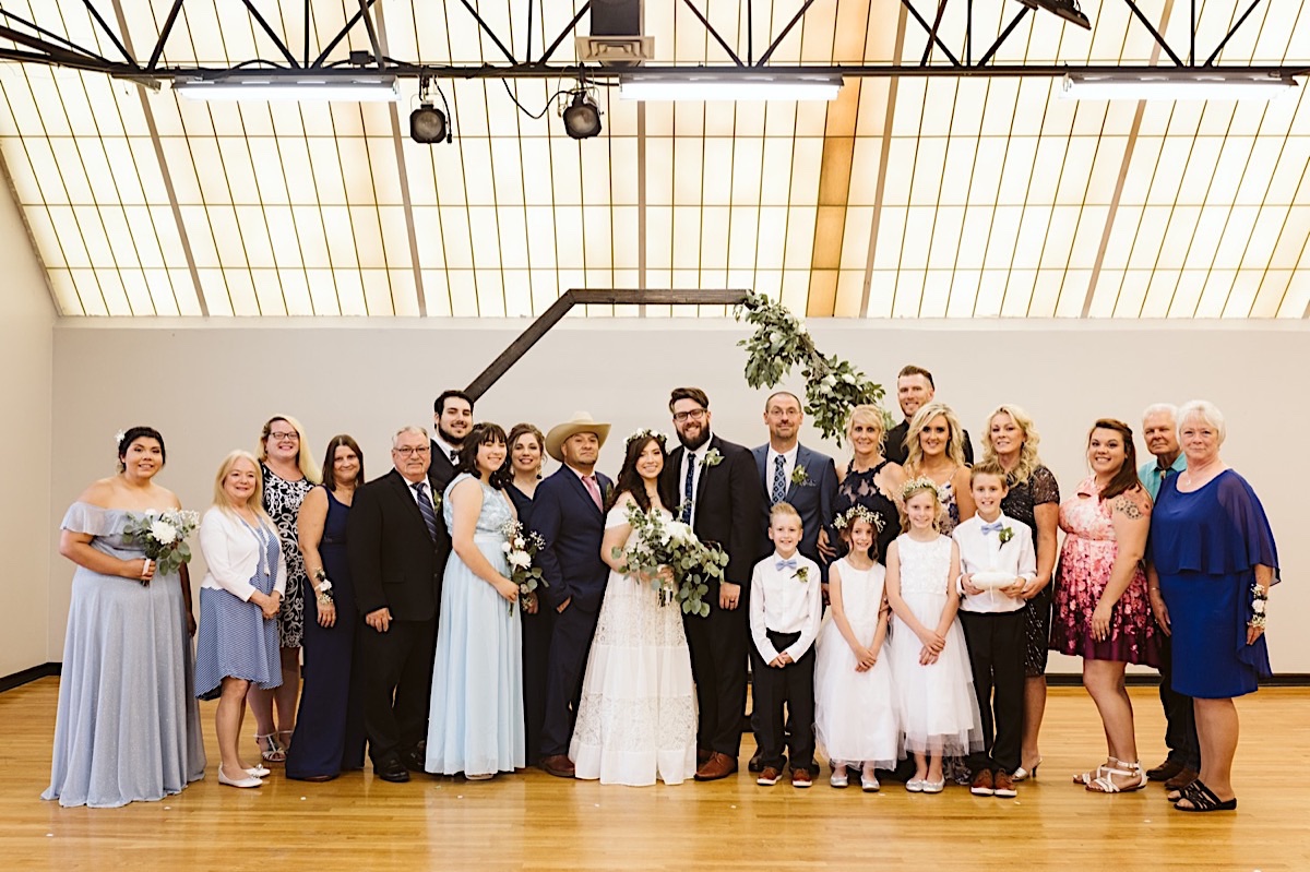 Bride and groom with their families under a skylight at their Creative Arts Guild wedding in Dalton, Georgia.