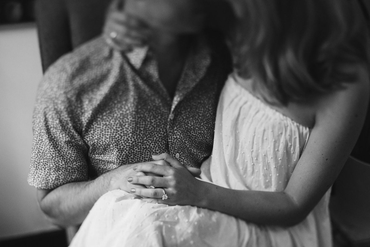 Man and woman cuddle, holding hands