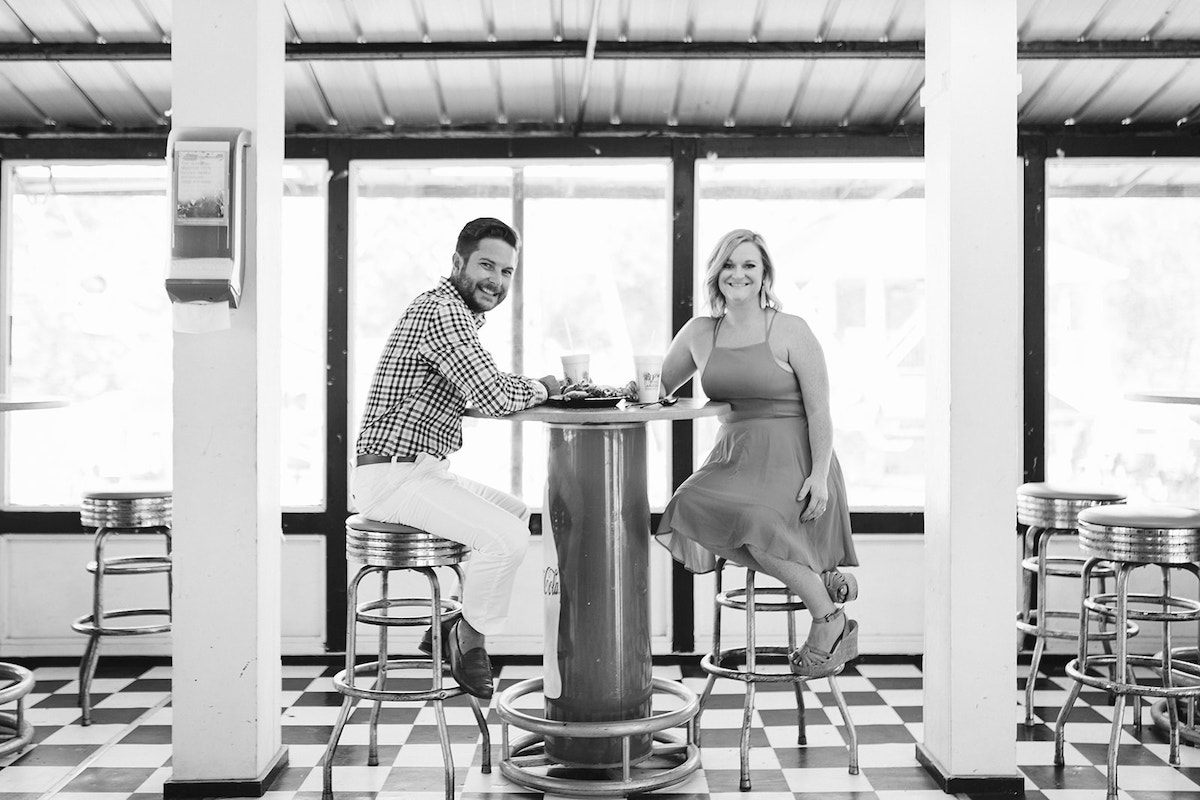 Man and woman sit on retro stools at a high-top table