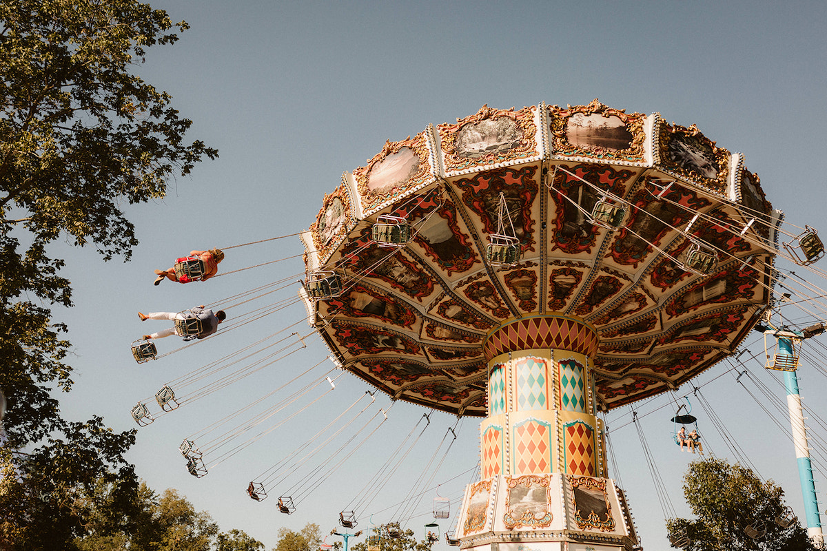 Man and woman on the swing carousel ride for their fun engagement photos at Lake Winnie in Chattanooga, TN