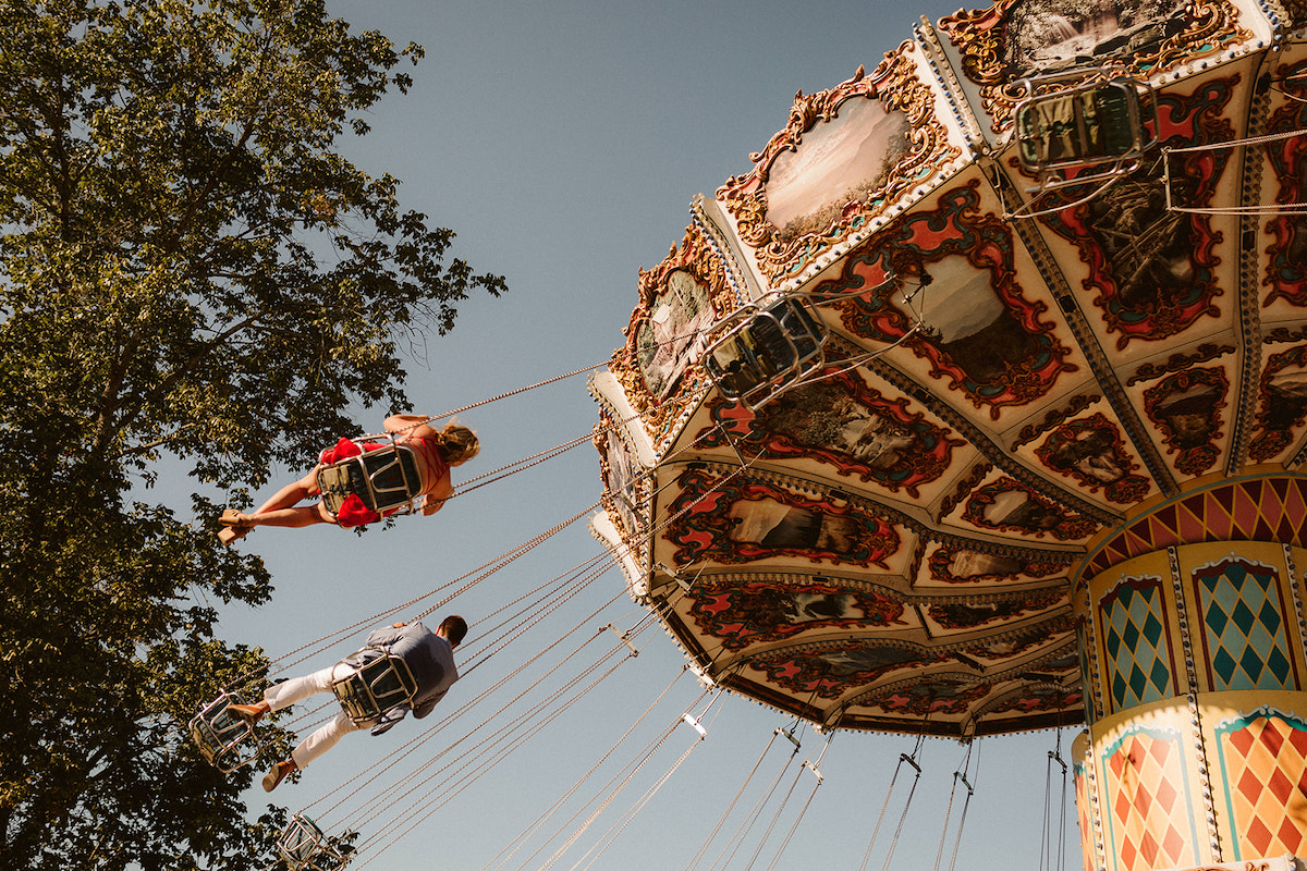 Man and woman on the swing carousel ride for their fun engagement photos at Lake Winnie in Chattanooga, TN