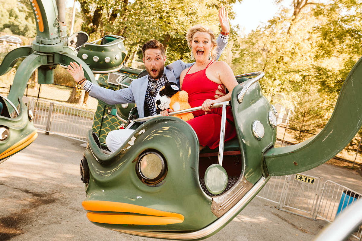 Man and woman make silly faces on frog-shaped carnival ride at Lake Winnie