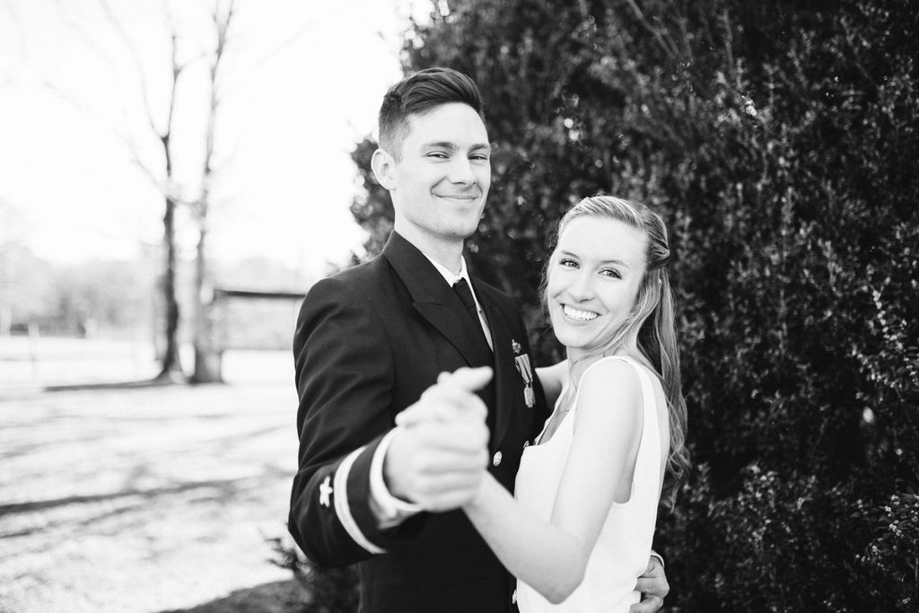 Bride and groom share a dance in front of greenery