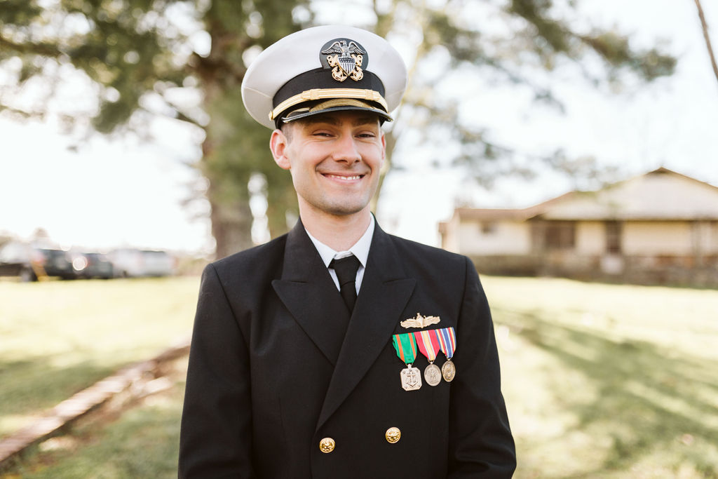Groom smiling in his military dress uniform and hat