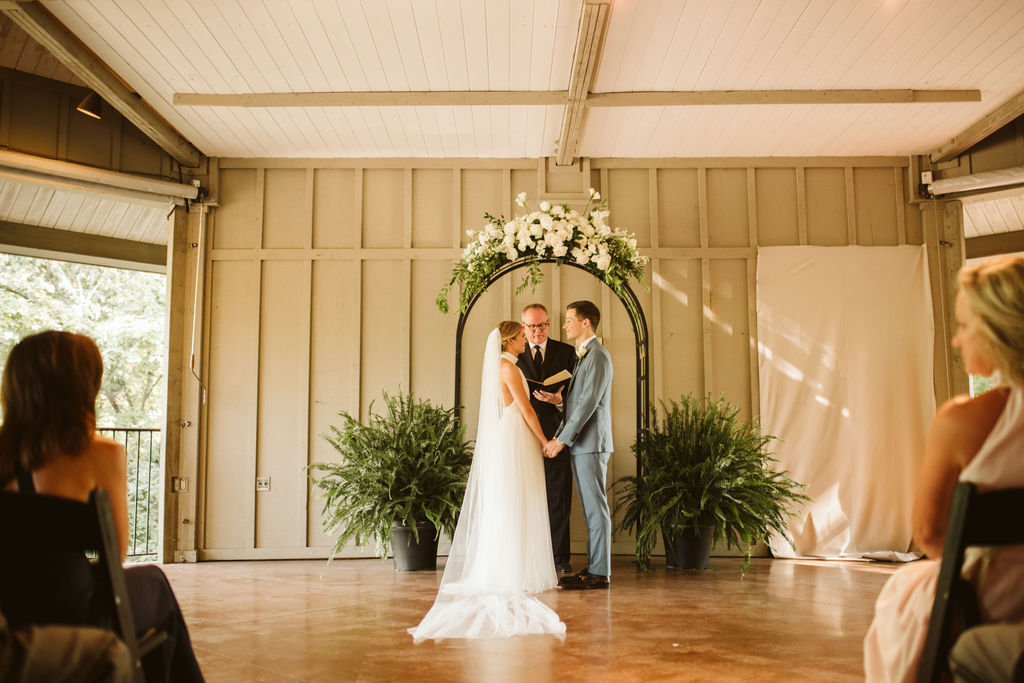 Bride and groom stand with minister under simple floral archway during Lookout Mountain Chattanooga Tennessee wedding ceremony