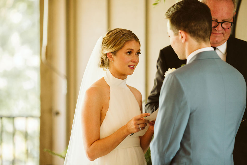 Bride reads vows to groom under simple floral archway during Lookout Mountain Chattanooga Tennessee wedding ceremony