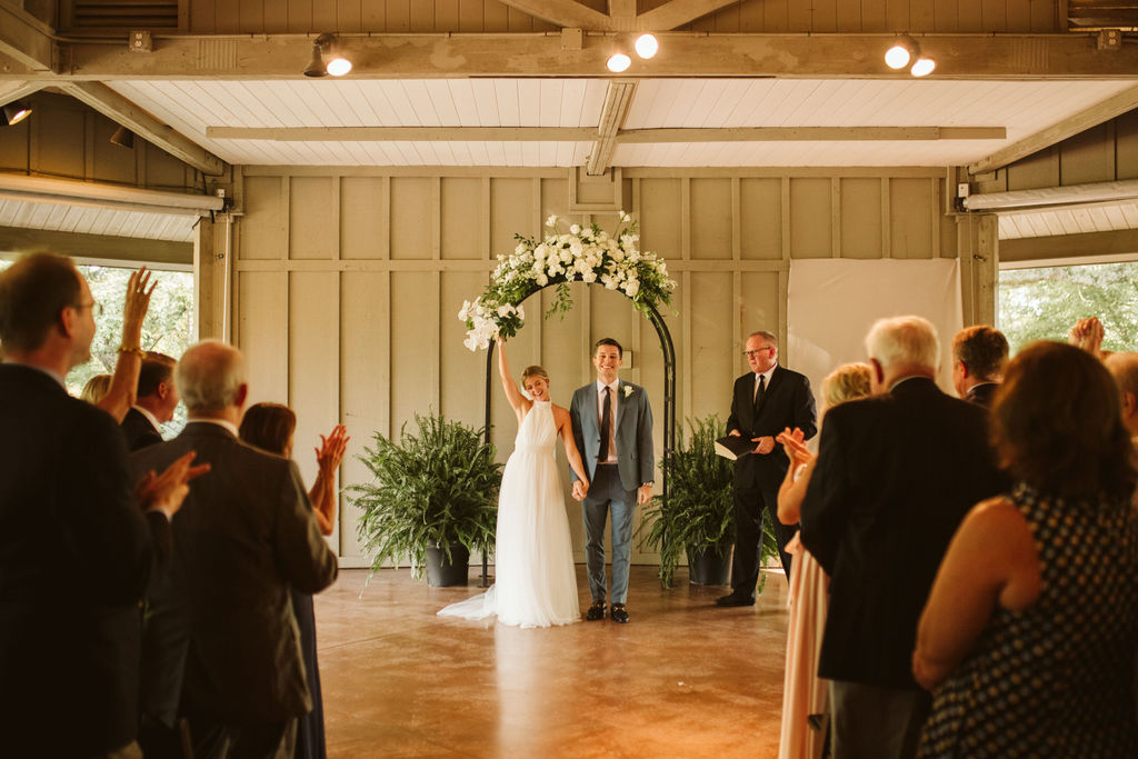 Bride raises bouquet in victory solute during Lookout Mountain wedding ceremony in Chattanooga, Tennessee