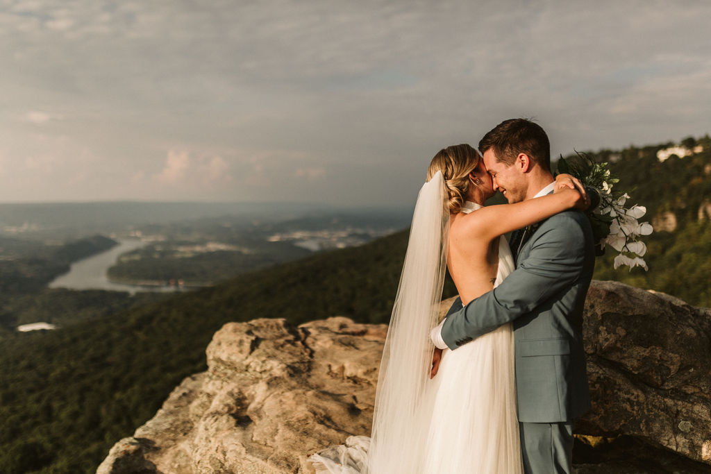 Bride and groom hug each other tightly at Sunset Rock on Lookout Mountain overlooking Chattanooga, Tennessee