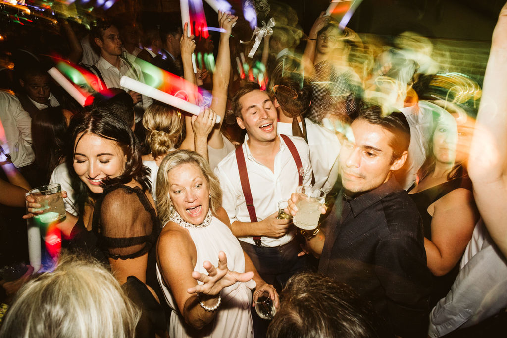 Wedding guests sing and dance with glow sticks during downtown Chattanooga wedding reception