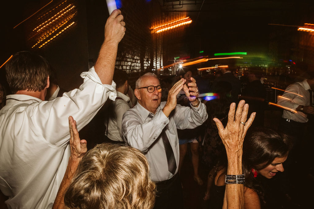 Wedding guests sing and dance with glow sticks during downtown Chattanooga wedding reception