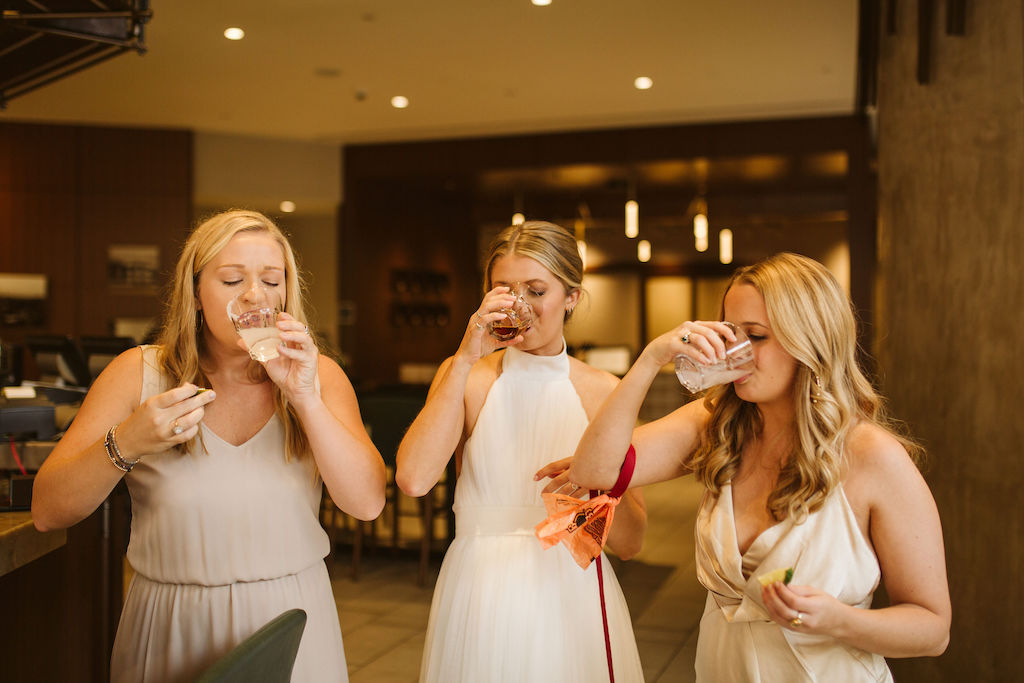 Bride and two friends enjoy shots in hotel lobby bar