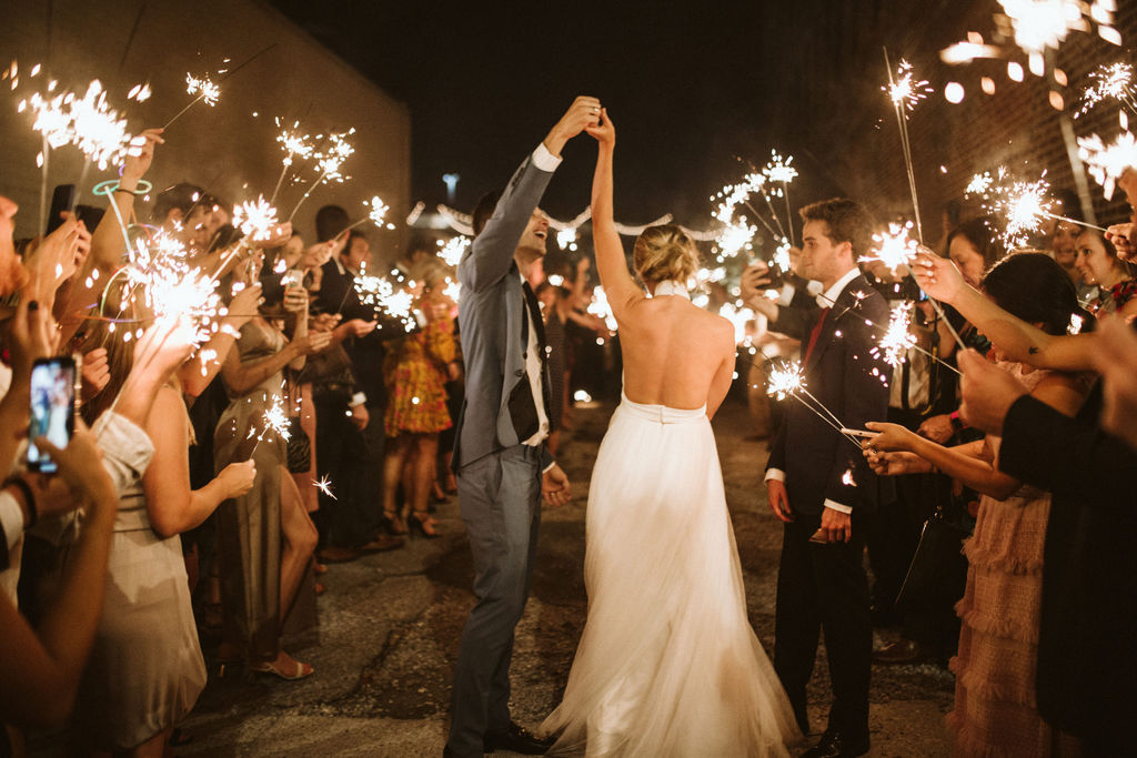 Groom twirls bride between two rows of sparklers at the end of their downtown Chattanooga wedding reception