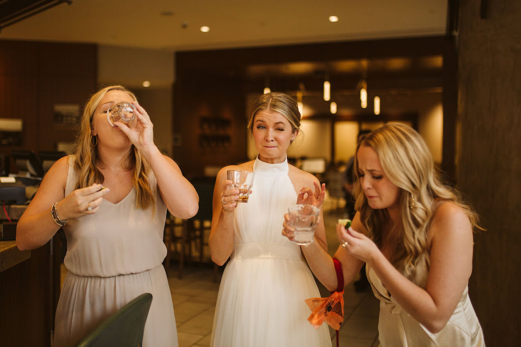 Bride and two friends enjoy shots in hotel lobby bar