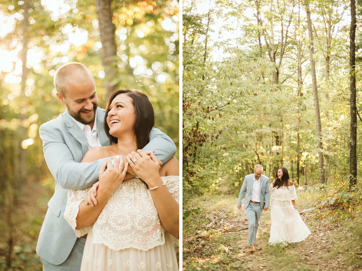 Man in light blue suit and woman in white lacy dress stand beneath tall trees on Raccoon Mountain