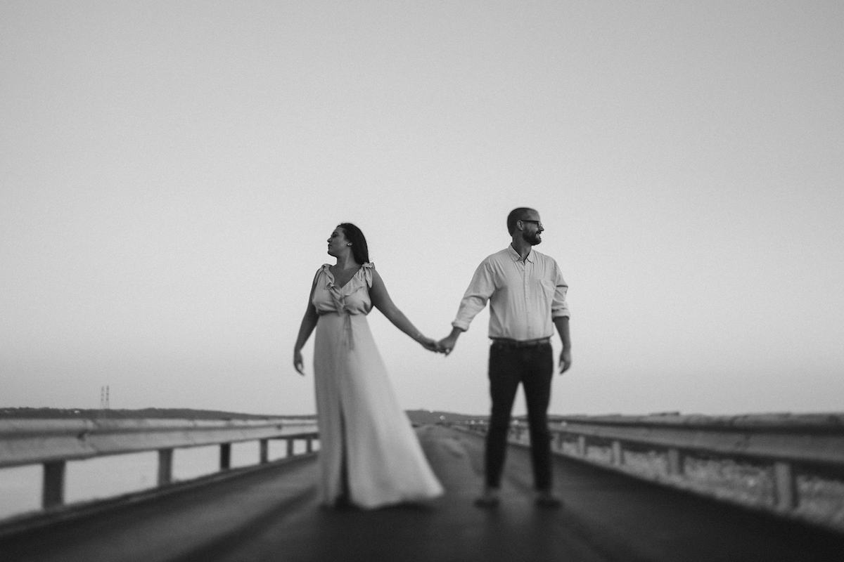 Man and woman stand hand-in-hand on Raccoon Mountain's loop drive at golden hour.