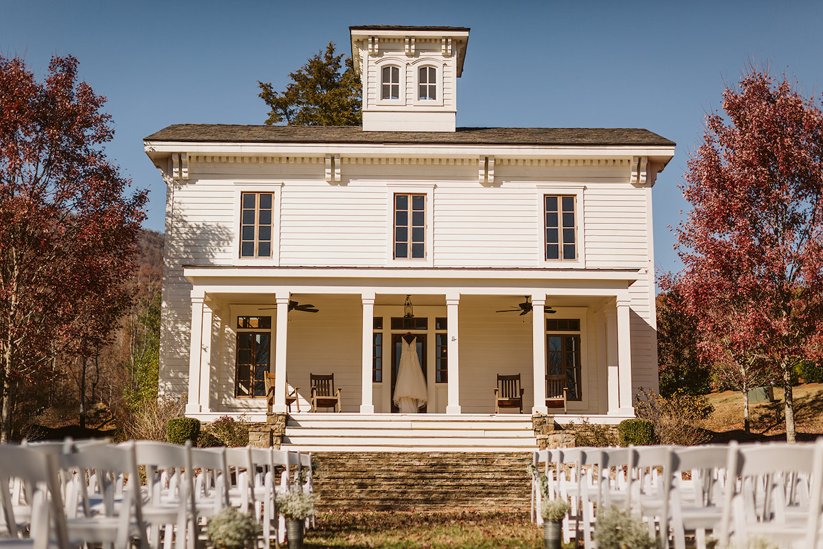 Wedding dress hangs on the door under the wide front port of Peacock Hall, and Italianate style farmhouse near Chattanooga