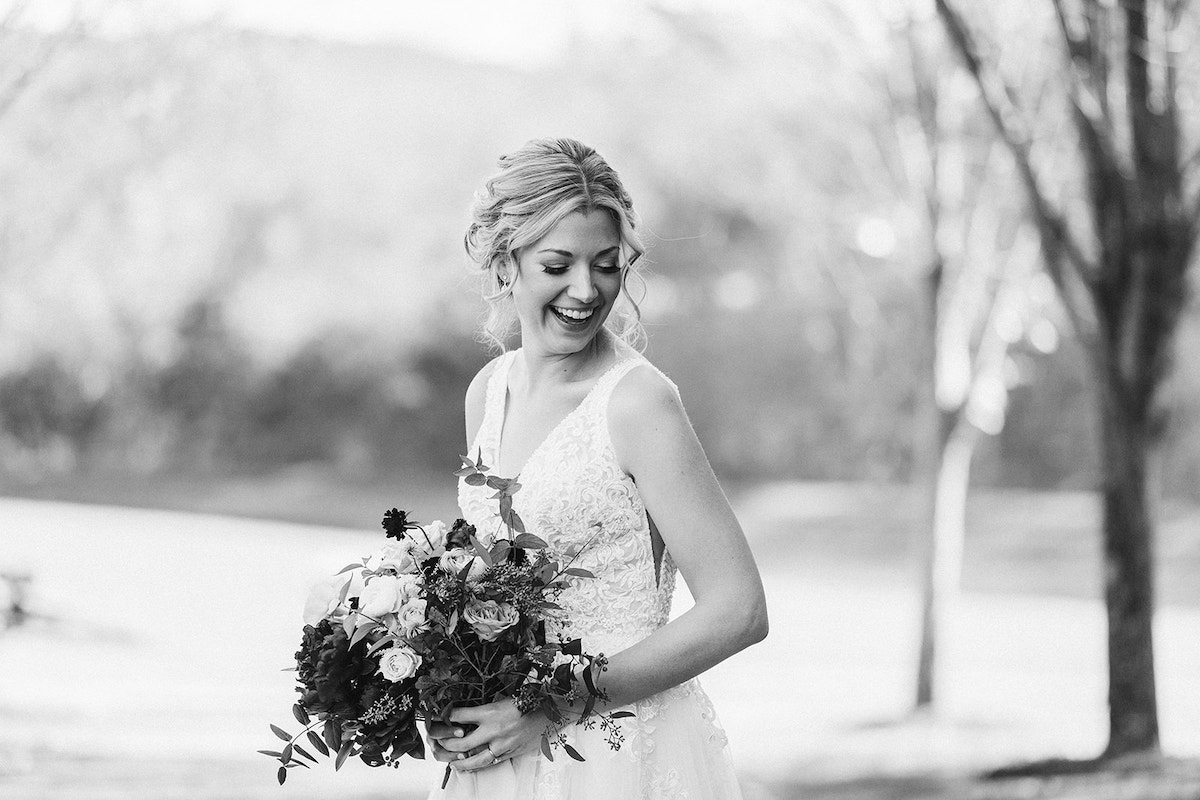 Bride laughs as she holds her Petaline floral bouquet