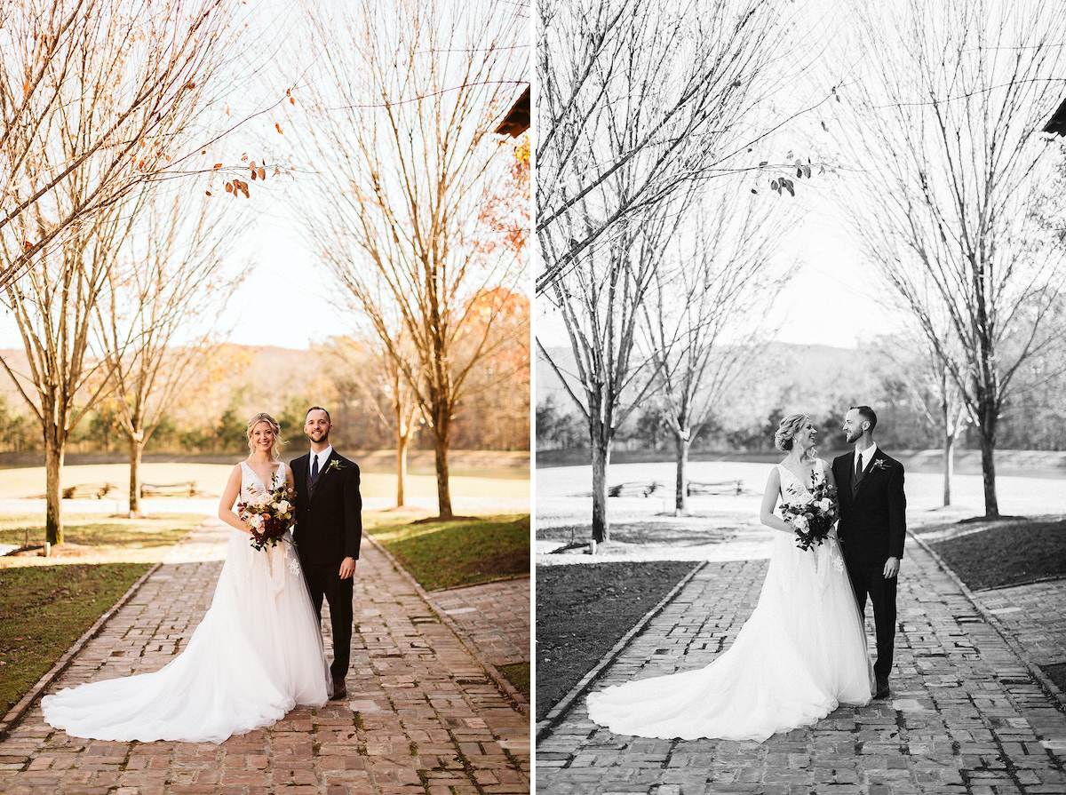Bride and groom smile at each other on antique brick carriage path between trees
