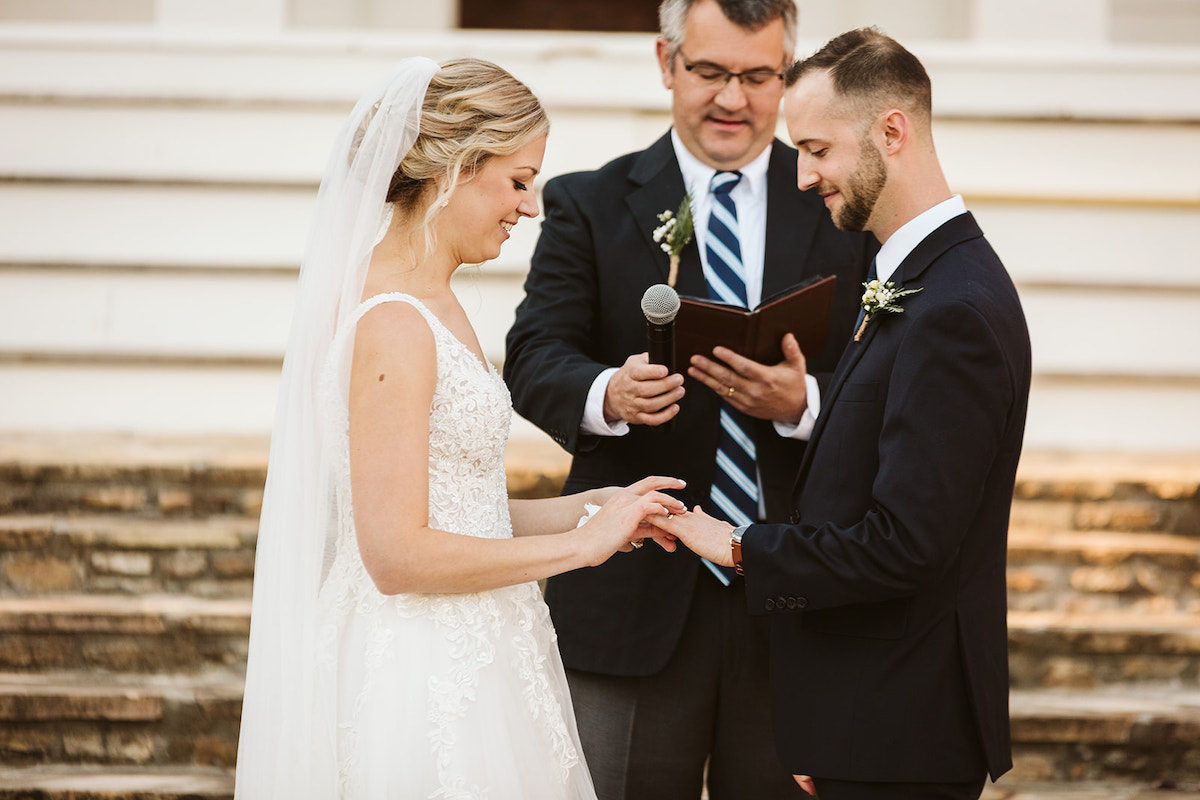 Bride places a ring on groom's finger