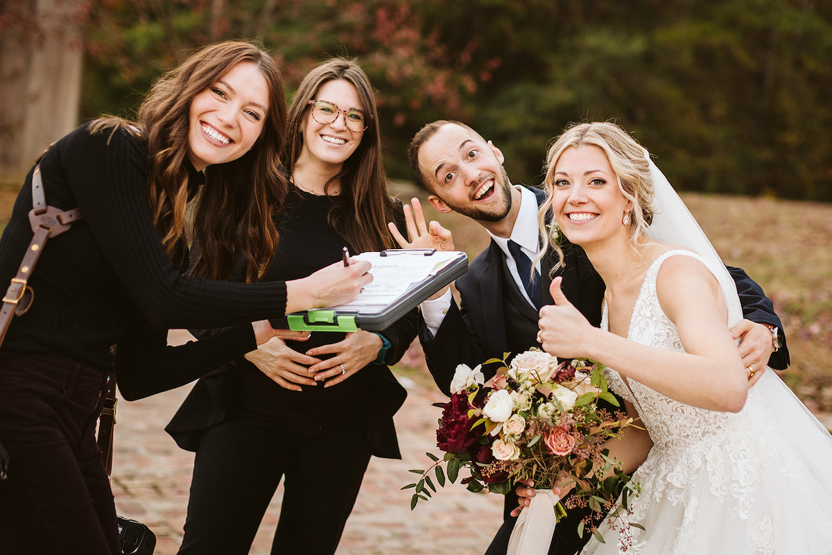 Rachel Crowe, Chattanooga wedding photographer, signs marriage license for her bride and groom as they all smile