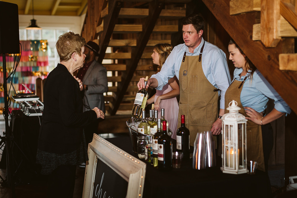 Chattanooga's BarCart bartenders present a bottle of white wine to a guest with other beer and wine options on the table