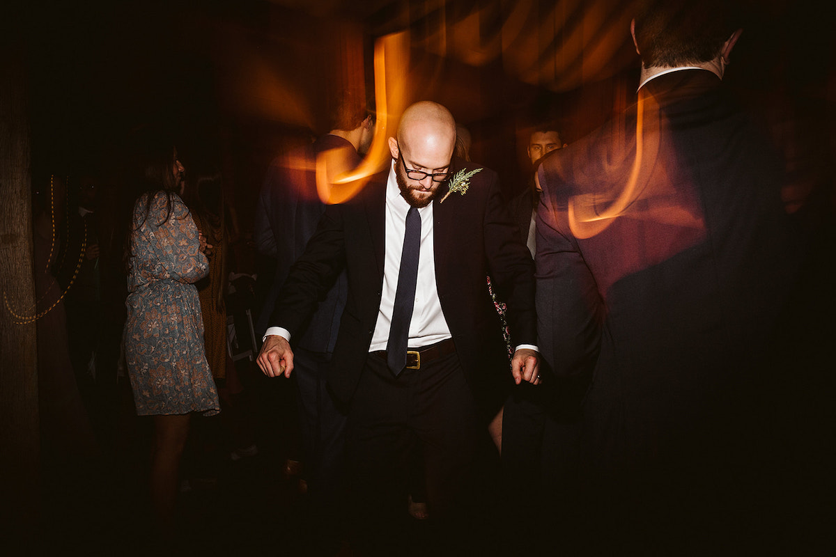 man in dark suit and tie dances