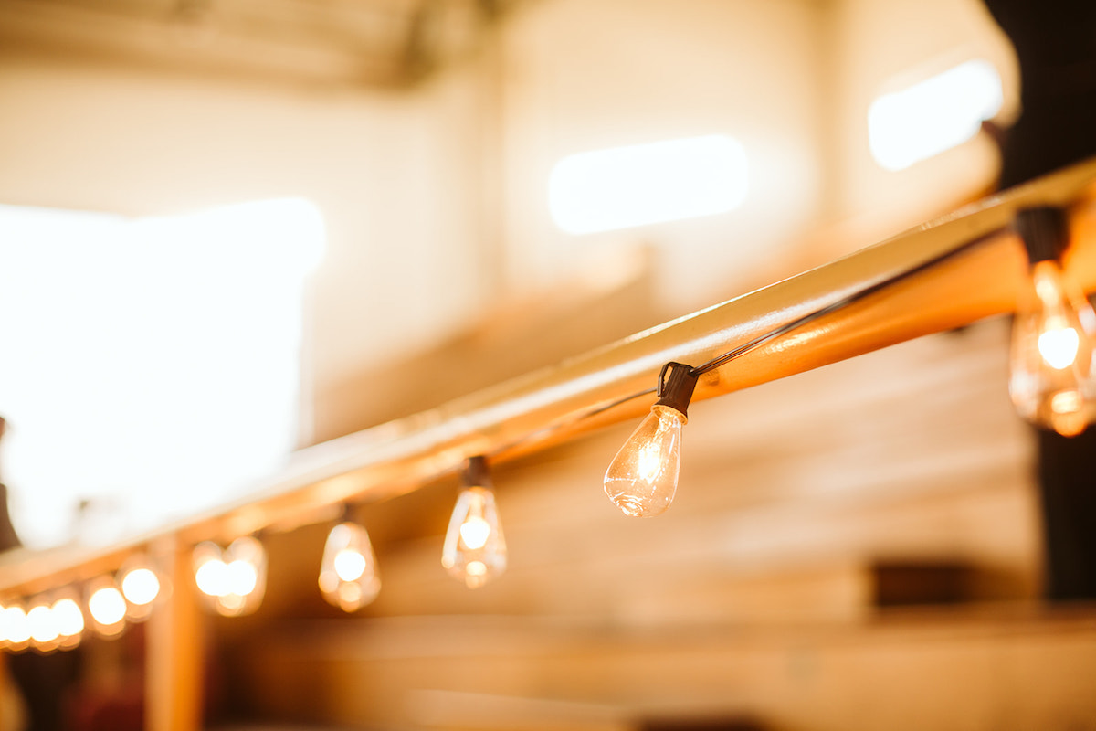 String patio lights strung along orange metal railing